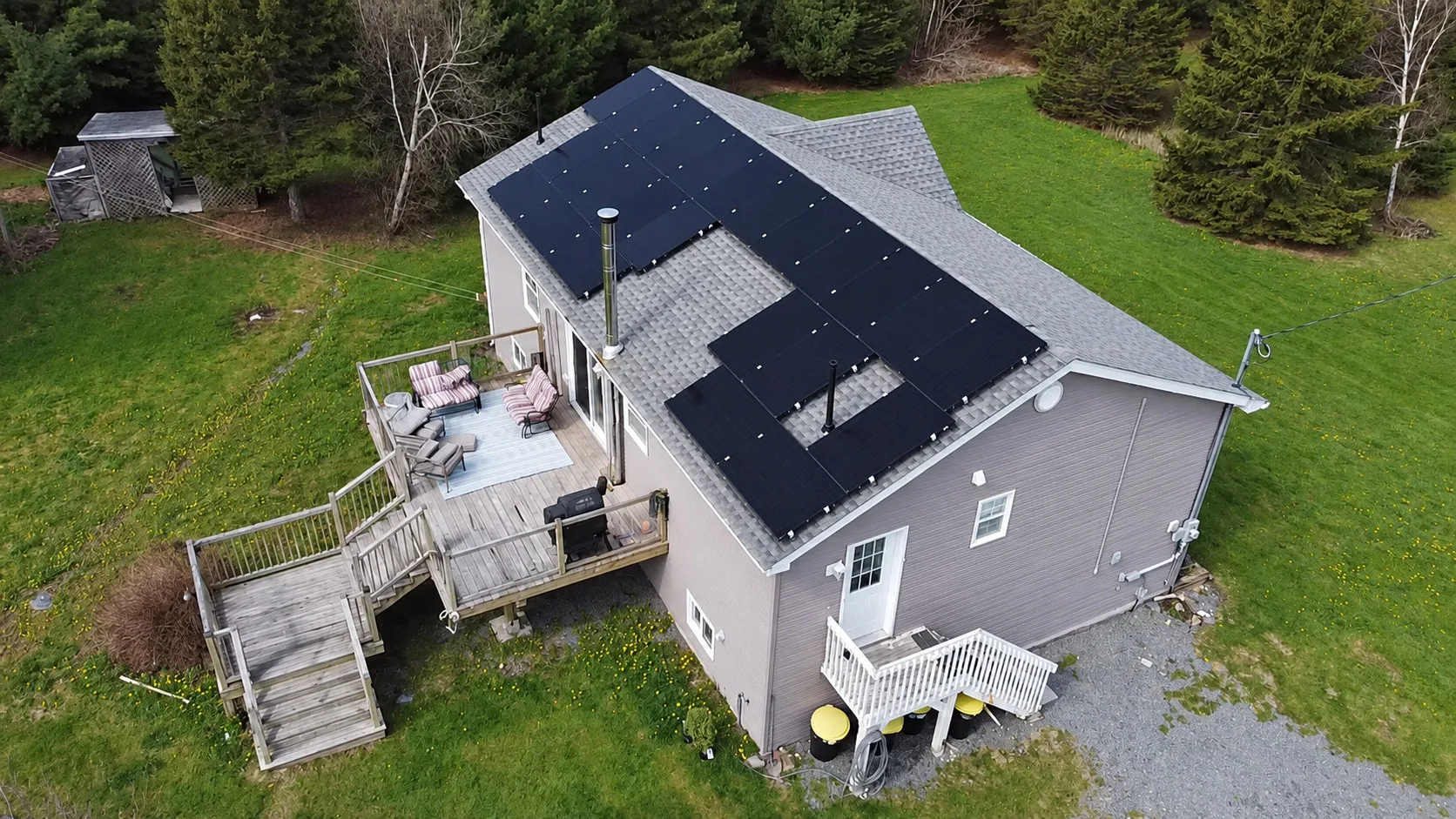 Grey home with a back deck and a solar array on its main roof